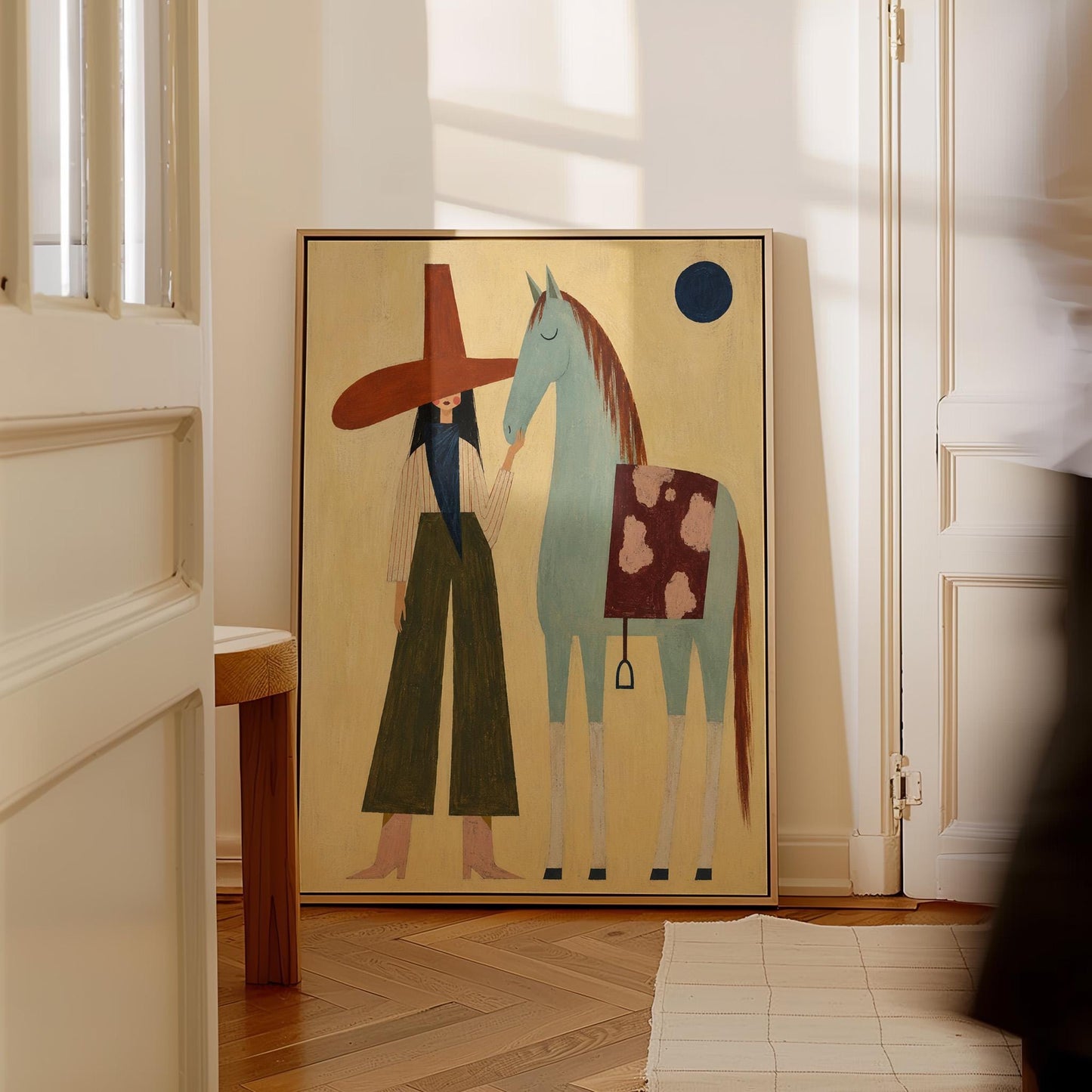 Woman in a wide red hat standing beside a gentle blue horse in the desert, canvas print presented in a light, minimal room