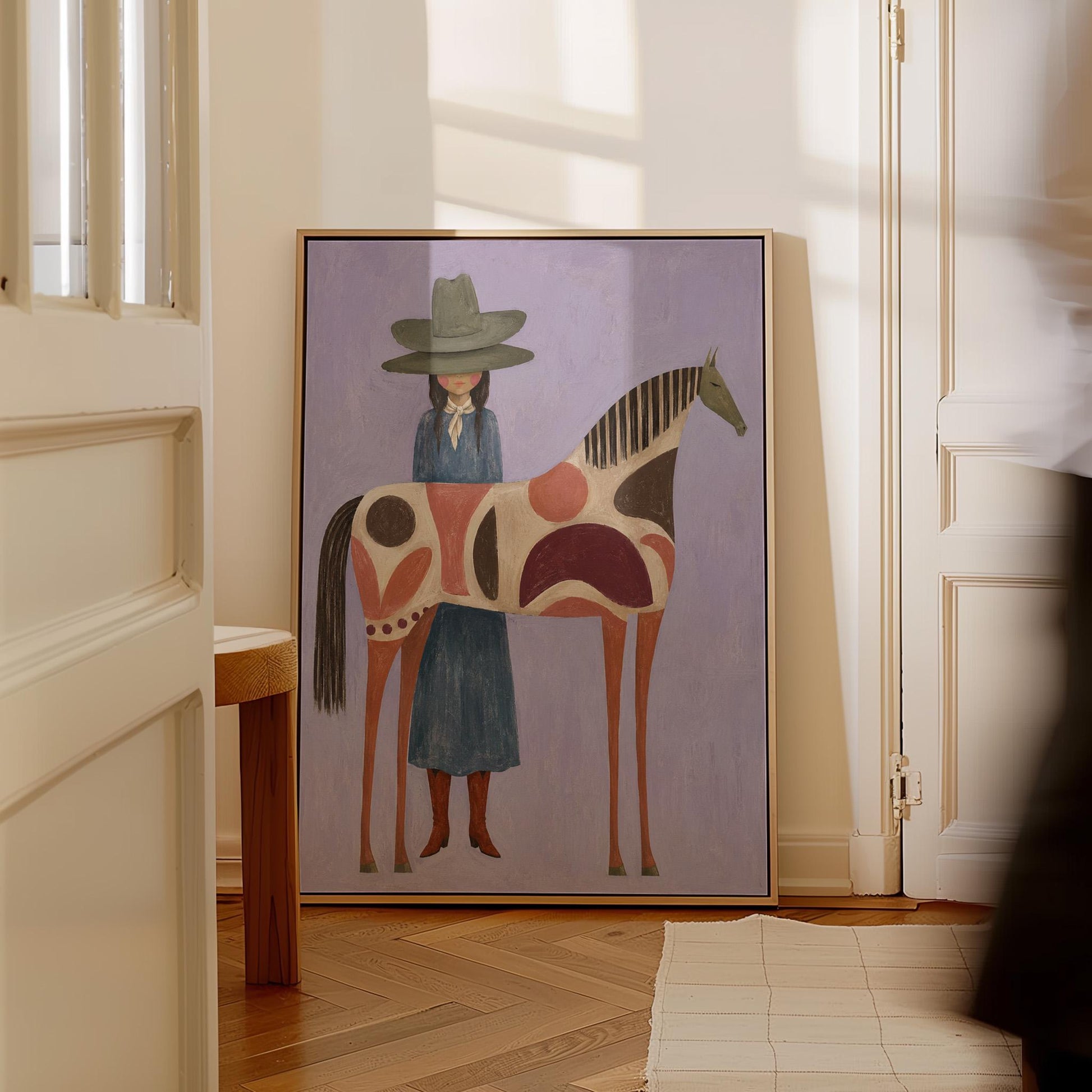 Woman in an olive hat before a patterned folk horse on a lavender ground, canvas print seen in a warm interior with natural light