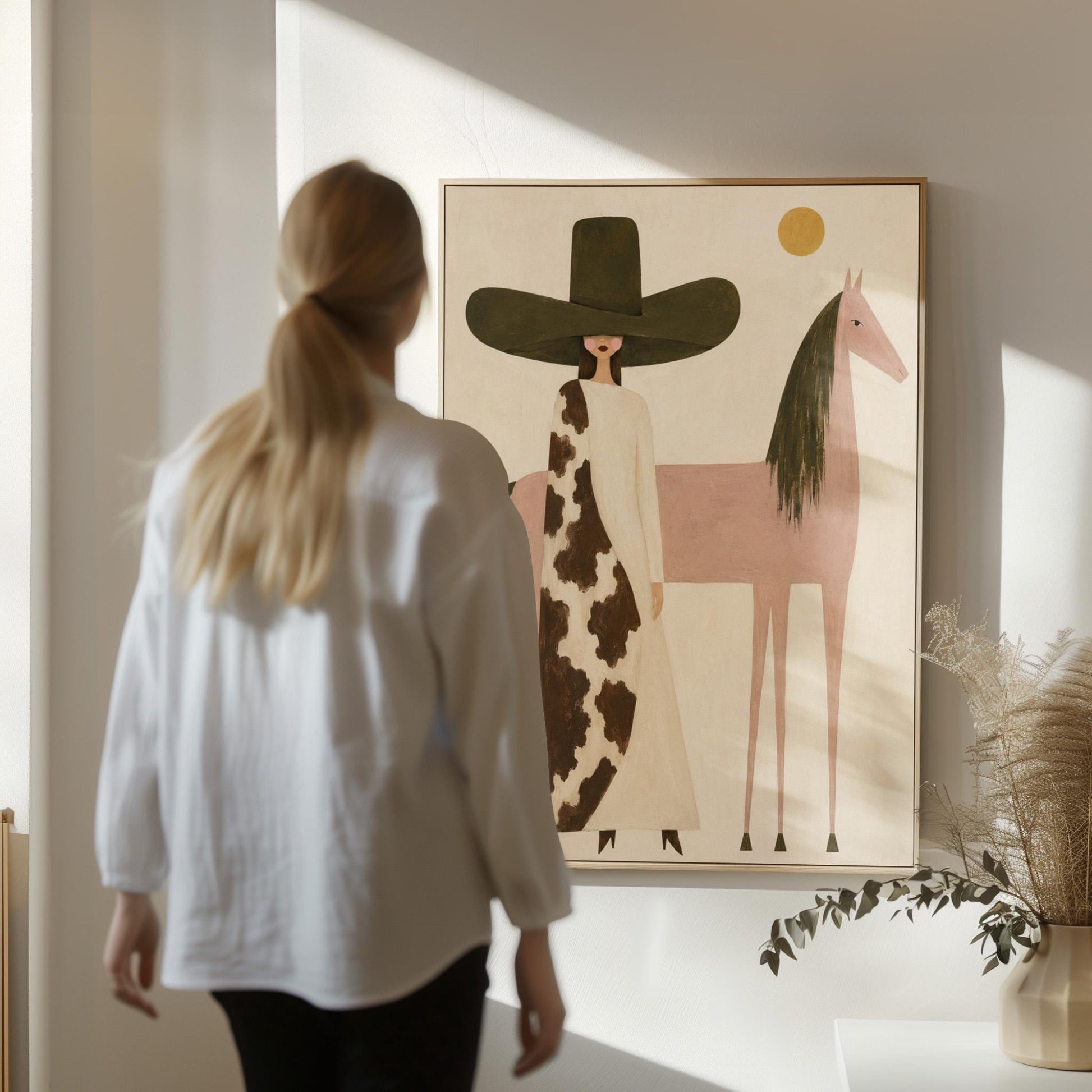 Woman in a tall dark hat standing beside a soft pink horse with olive mane, canvas wall art styled against a soft white wall