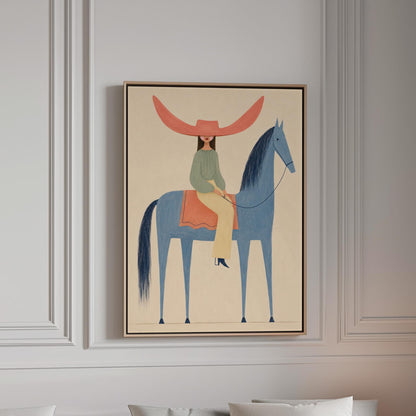 Cowgirl in a dramatic red hat riding a slender blue horse across pale sand, canvas print in a bright room with natural daylight
