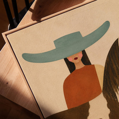 Woman in a teal hat beside a brown and white pinto horse in warm light, canvas print in a warm, minimally styled interior