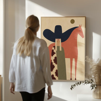 Cowgirl in a black sombrero and cow print cape beside a rust red horse, canvas print displayed on a neutral wall in a styled interior