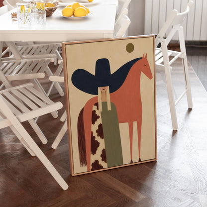 Cowgirl in a black sombrero and cow print cape beside a rust red horse, canvas print shown in a sunlit, contemporary room