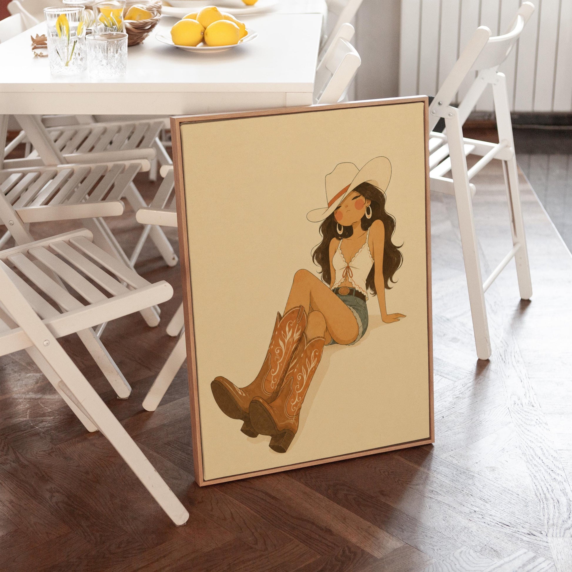 Cowgirl in denim shorts and cowboy boots leaning back under a wide pale hat, canvas print displayed on a neutral wall in a styled interior