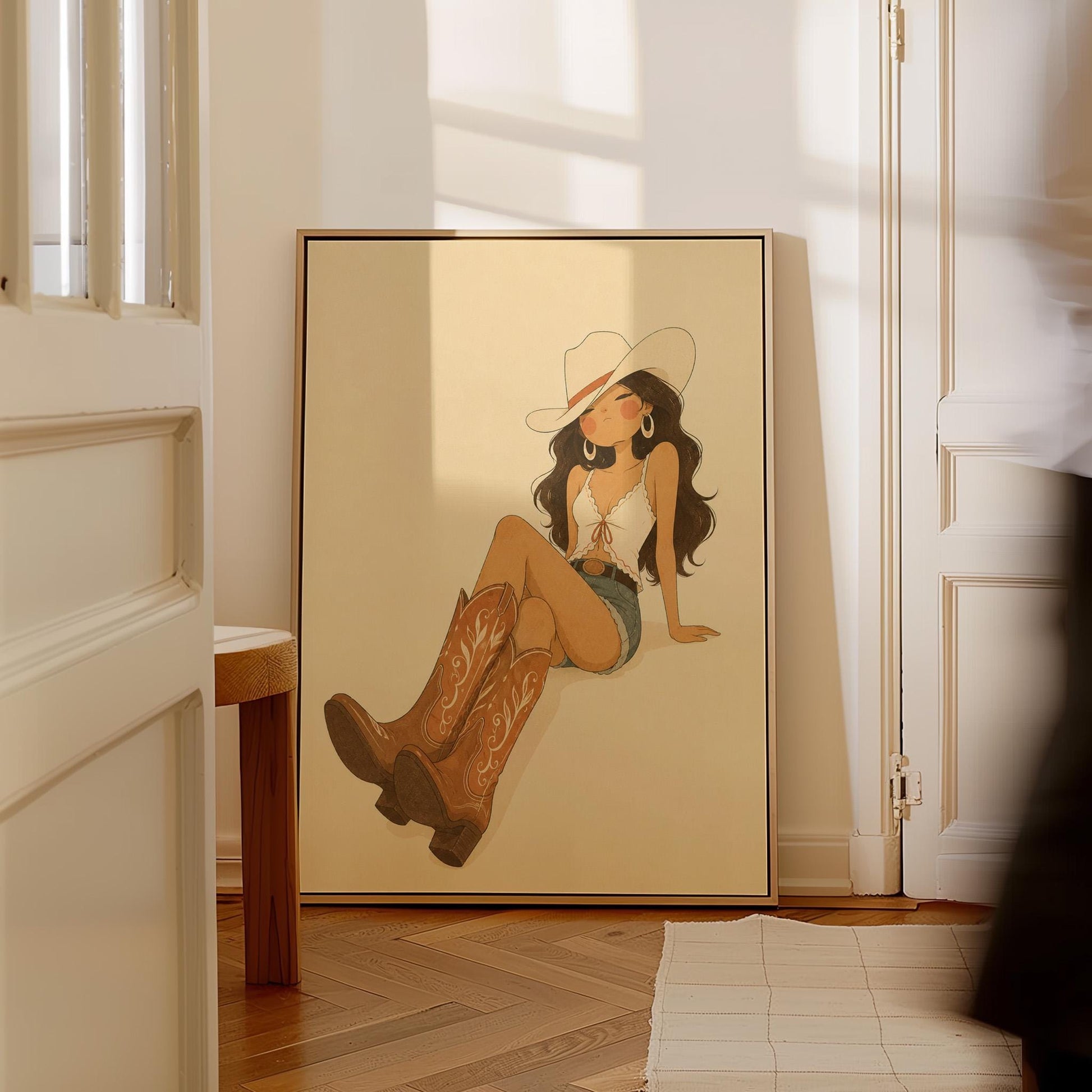 Cowgirl in denim shorts and cowboy boots leaning back under a wide pale hat, canvas print hanging in a calm, modern living space