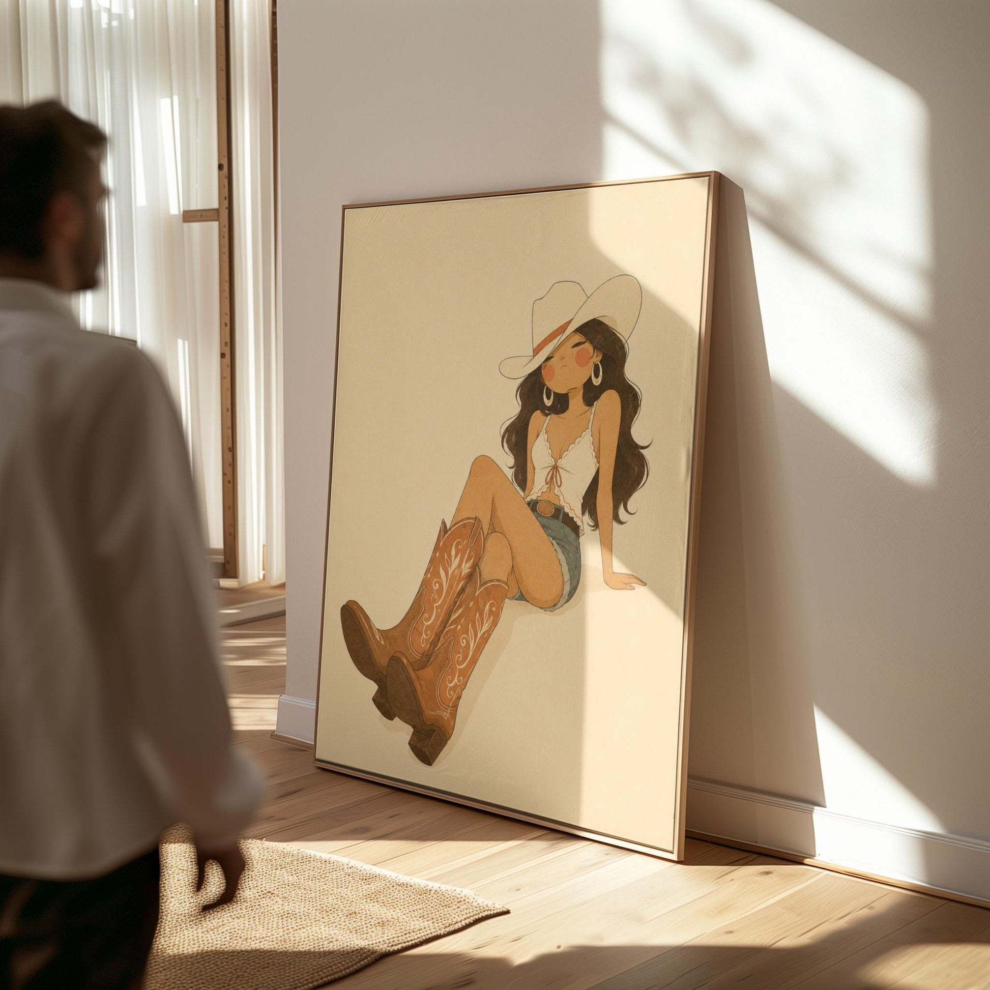 Cowgirl in denim shorts and cowboy boots leaning back under a wide pale hat, canvas wall art presented in a light, minimal room