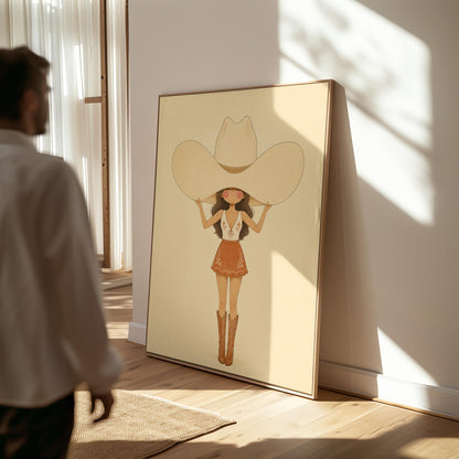 Cowgirl lifting an oversized cream cowboy hat above her head in tall boots, canvas print shown in a sunlit, contemporary room