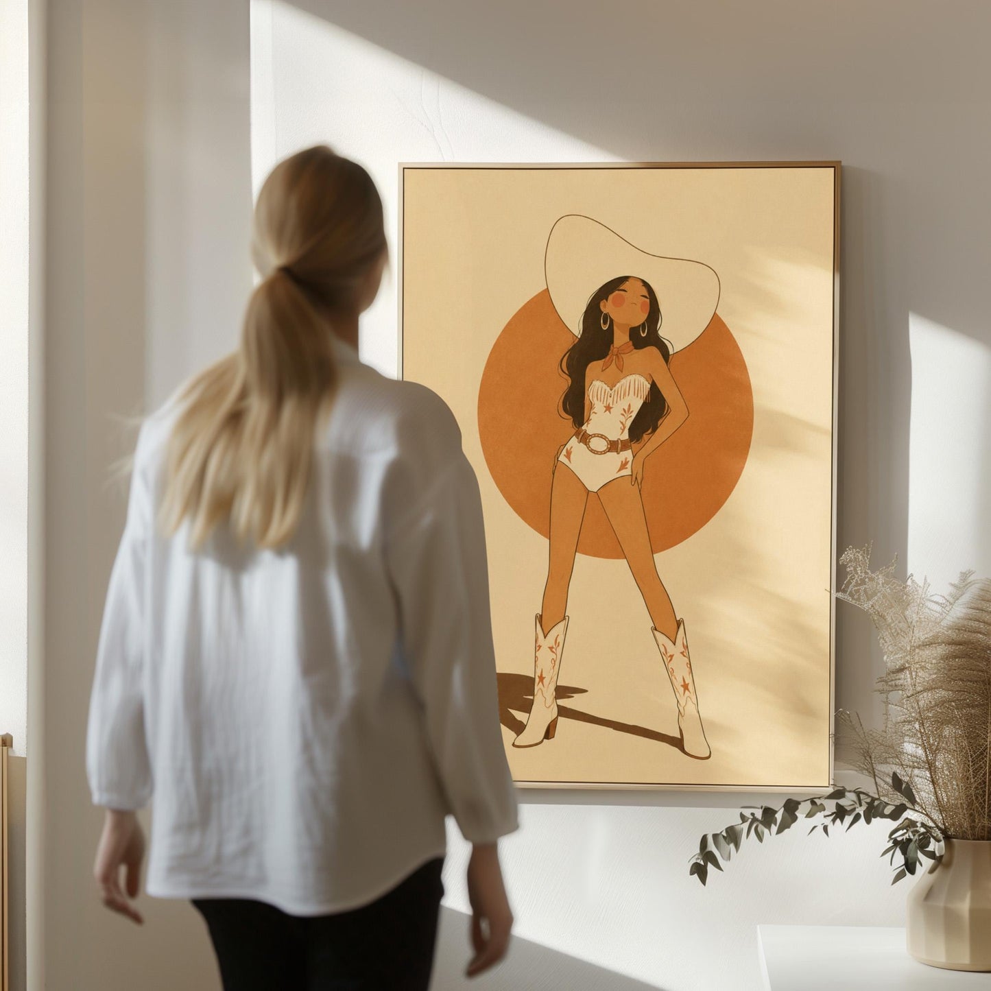 Cowgirl in a white star bodysuit against a large burnt orange sun disc, canvas wall art presented in a light, minimal room