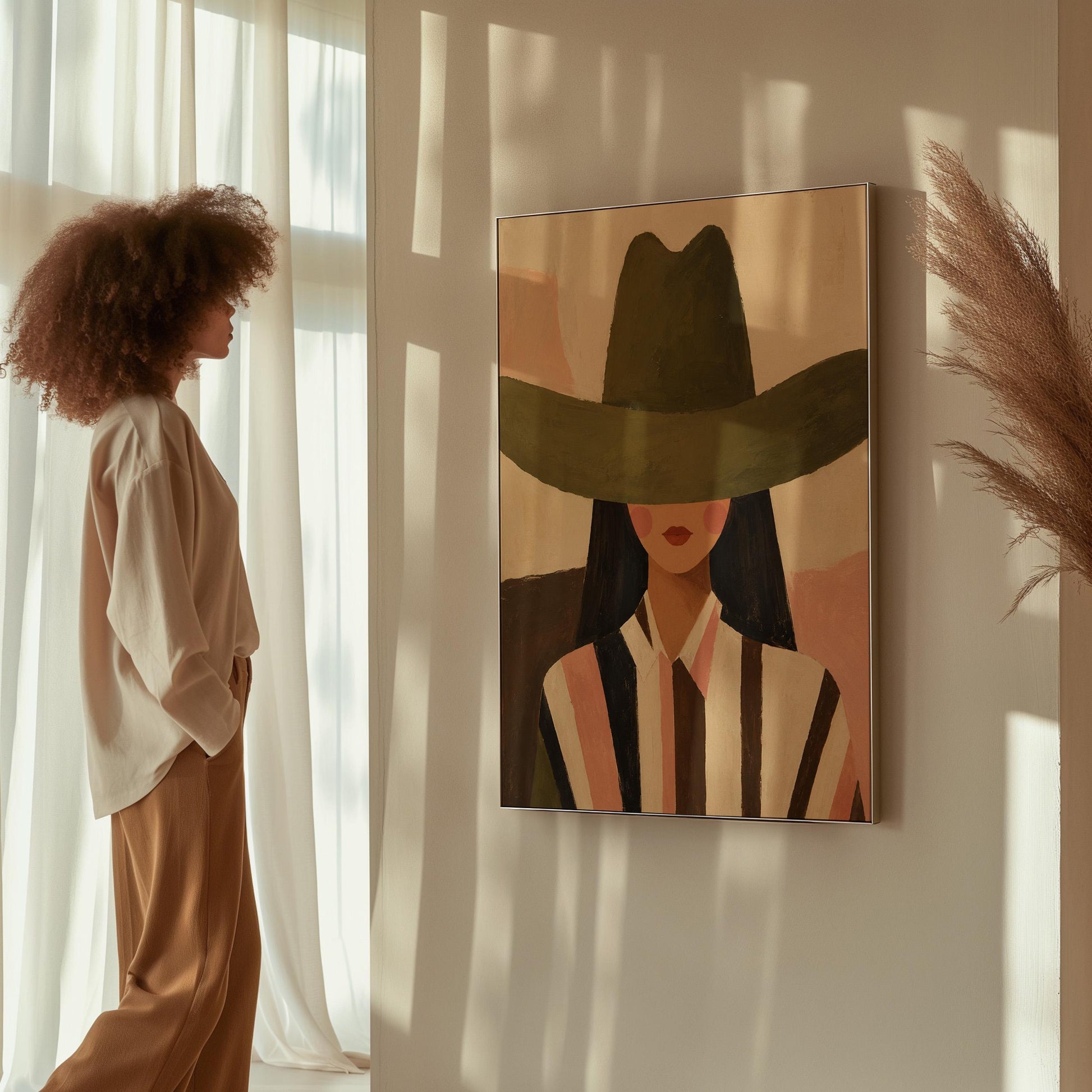 Faceless cowgirl portrait under a broad olive green hat, canvas print hanging in a calm, modern living space