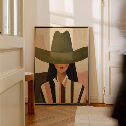 Faceless cowgirl portrait under a broad olive green hat, canvas print shown to scale in a furnished room