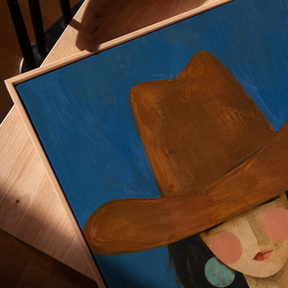 Cowgirl in a brown hat and turquoise earrings on cobalt blue, canvas print in a warm, minimally styled interior