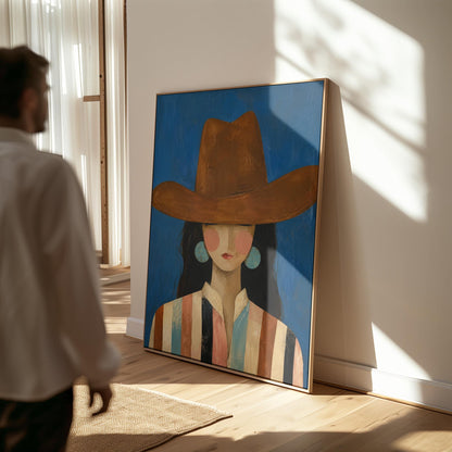 Cowgirl in a brown hat and turquoise earrings on cobalt blue, canvas print shown in a sunlit, contemporary room