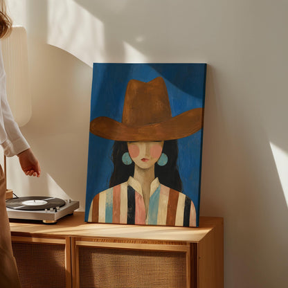 Cowgirl in a brown hat and turquoise earrings on cobalt blue, canvas wall art hanging in a calm, modern living space
