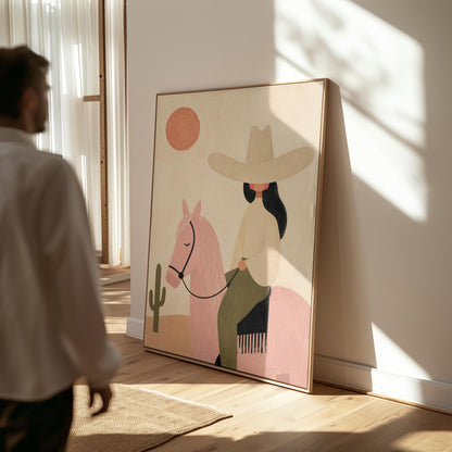 Cowgirl in a pale hat riding a soft pink horse past a desert cactus, canvas wall art on a quiet wall in a considered interior