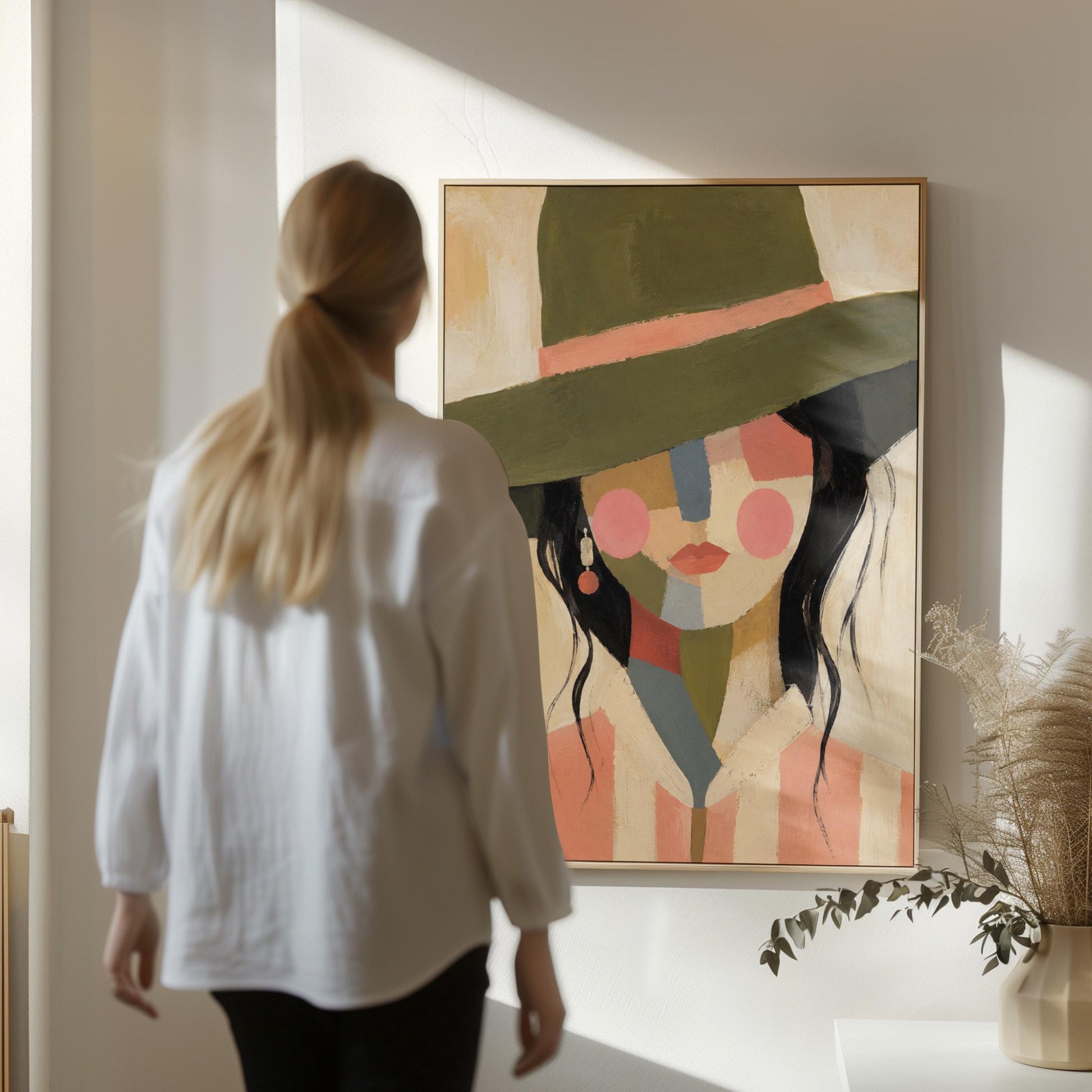 Cowgirl in olive hat with a patchwork face of soft color blocks, canvas wall art seen in a warm interior with natural light