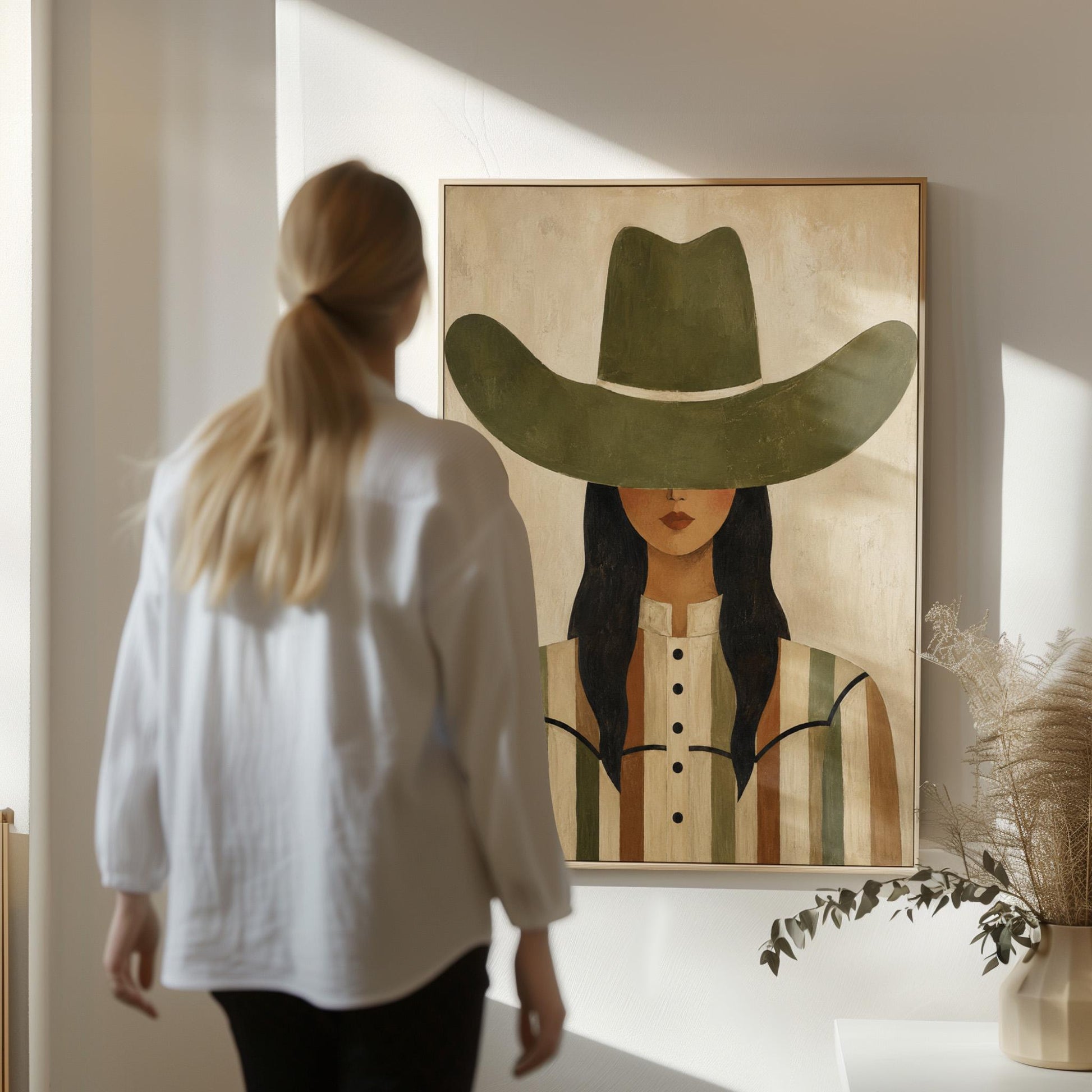 Cowgirl in olive hat and striped western shirt on sandy beige, canvas print shown in a sunlit, contemporary room