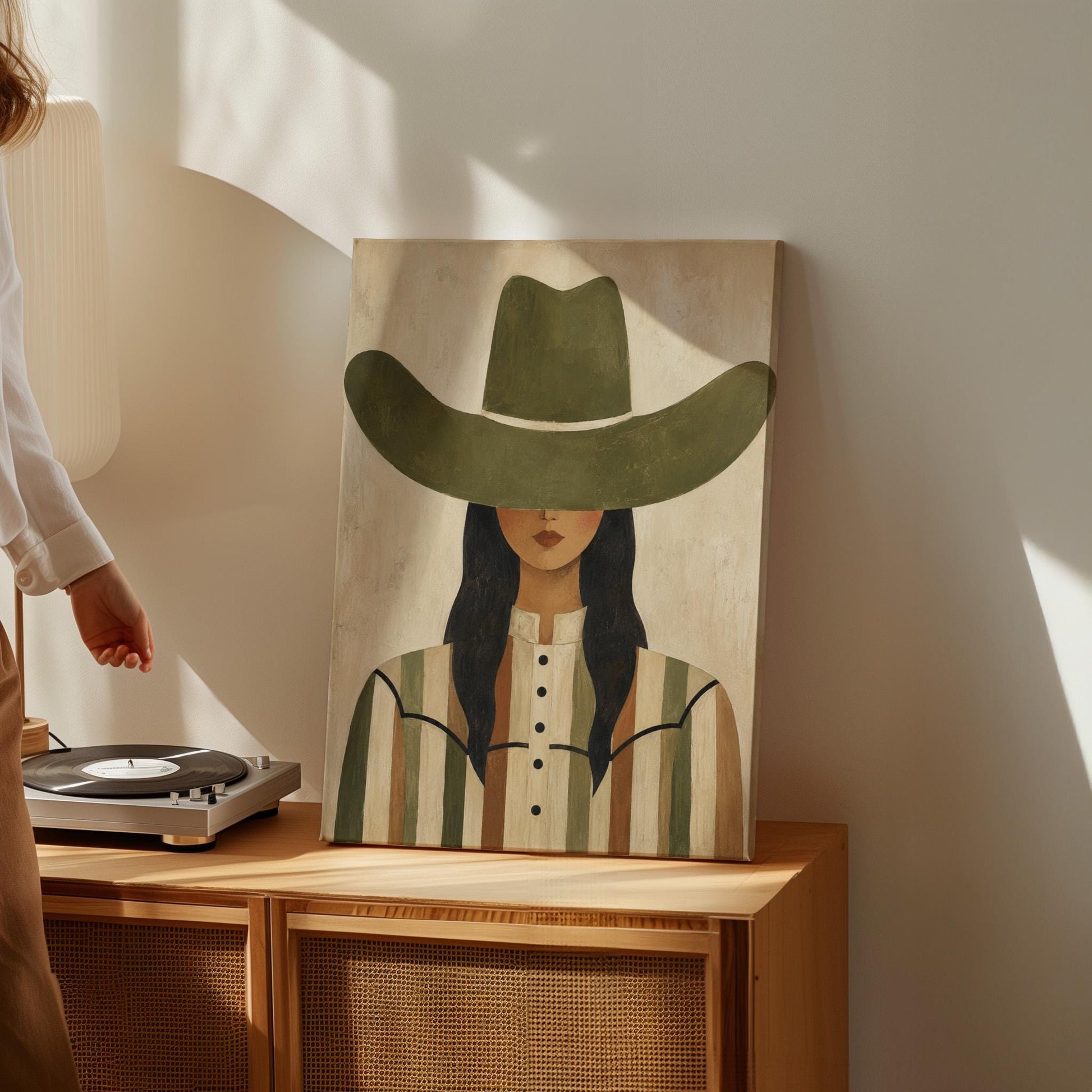Cowgirl in olive hat and striped western shirt on sandy beige, canvas wall art on a quiet wall in a considered interior
