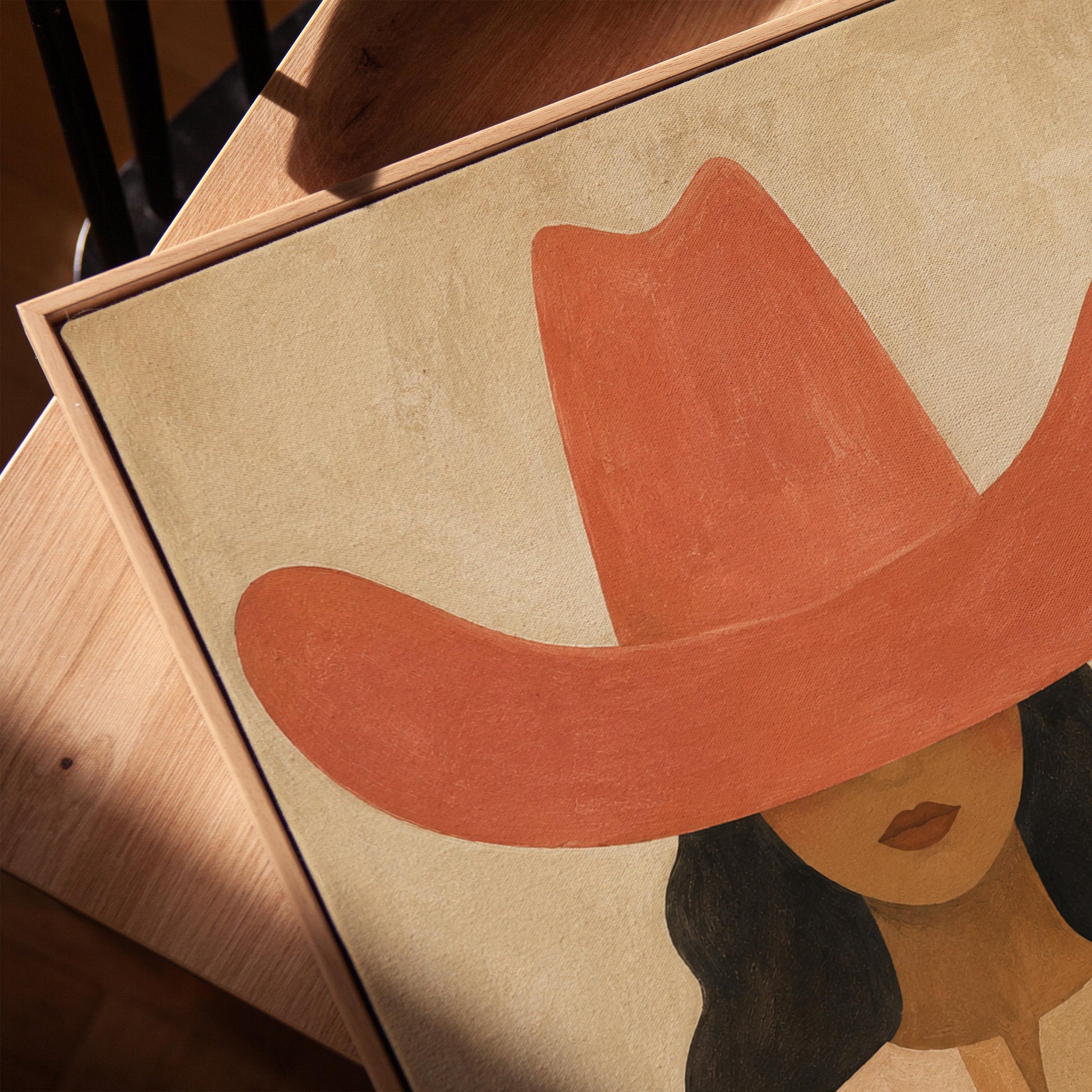 Cowgirl in a broad terracotta hat and patchwork western shirt, canvas print in a warm, minimally styled interior
