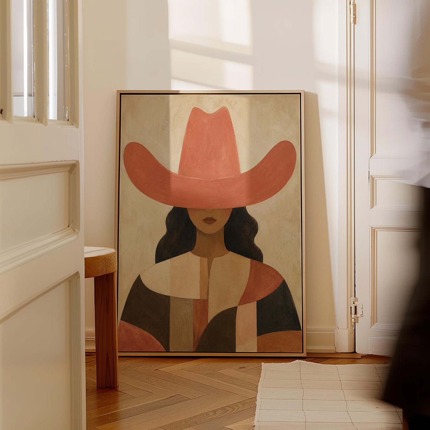 Cowgirl in a broad terracotta hat and patchwork western shirt, canvas wall art on a quiet wall in a considered interior
