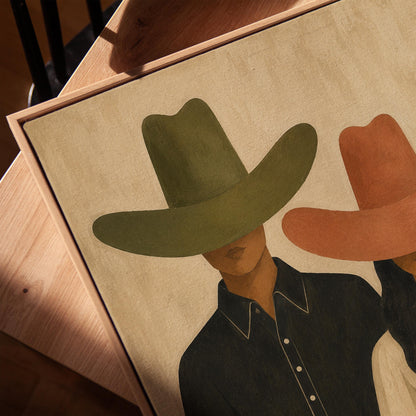 Cowboy and cowgirl standing side by side with hats tipped low, canvas print in a warm, minimally styled interior
