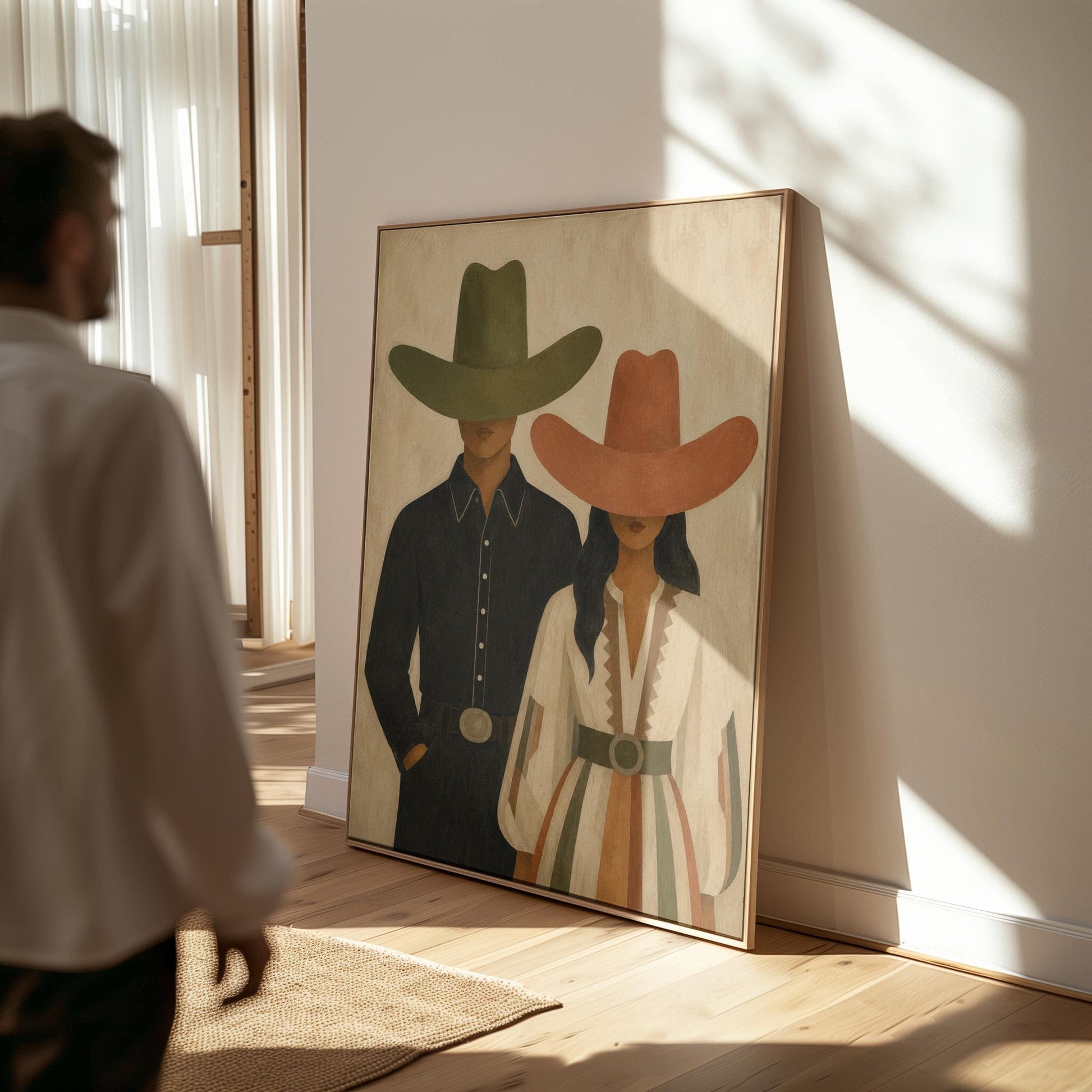 Cowboy and cowgirl standing side by side with hats tipped low, canvas print shown to scale in a furnished room