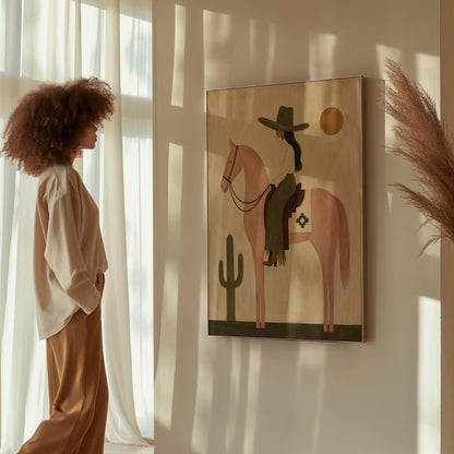 Cowgirl on a dusty pink horse beside a tall saguaro cactus, canvas print presented in a light, minimal room