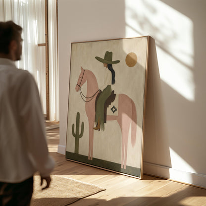 Cowgirl on a dusty pink horse beside a tall saguaro cactus, canvas print styled against a soft white wall