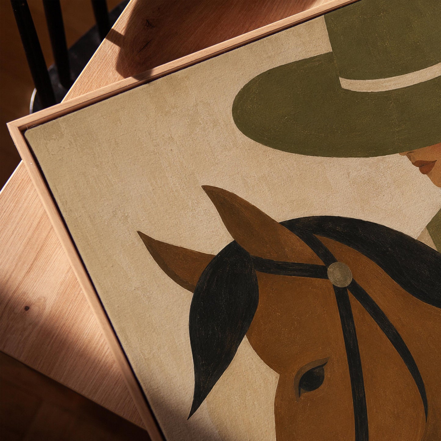 Bay horse in a bridle with a cowgirl in an olive hat behind, canvas print in a warm, minimally styled interior