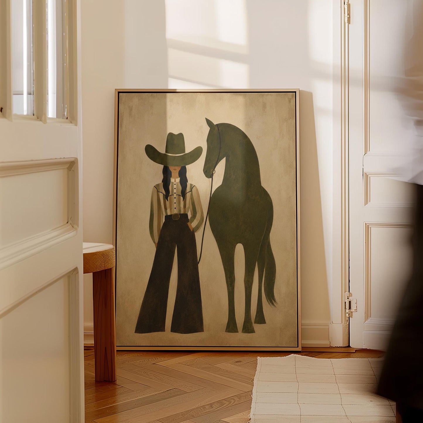 Cowgirl in wide trousers leading a flat olive green horse, canvas wall art styled against a soft white wall