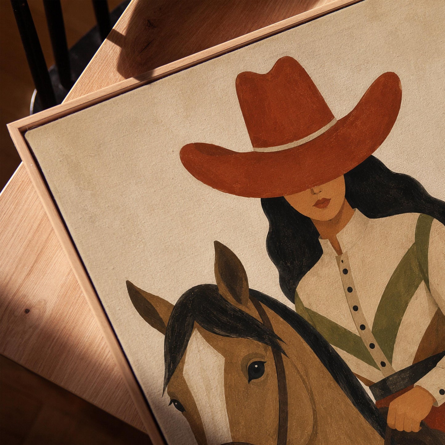 Cowgirl in a red hat riding a bay horse across an ochre desert, canvas print in a warm, minimally styled interior