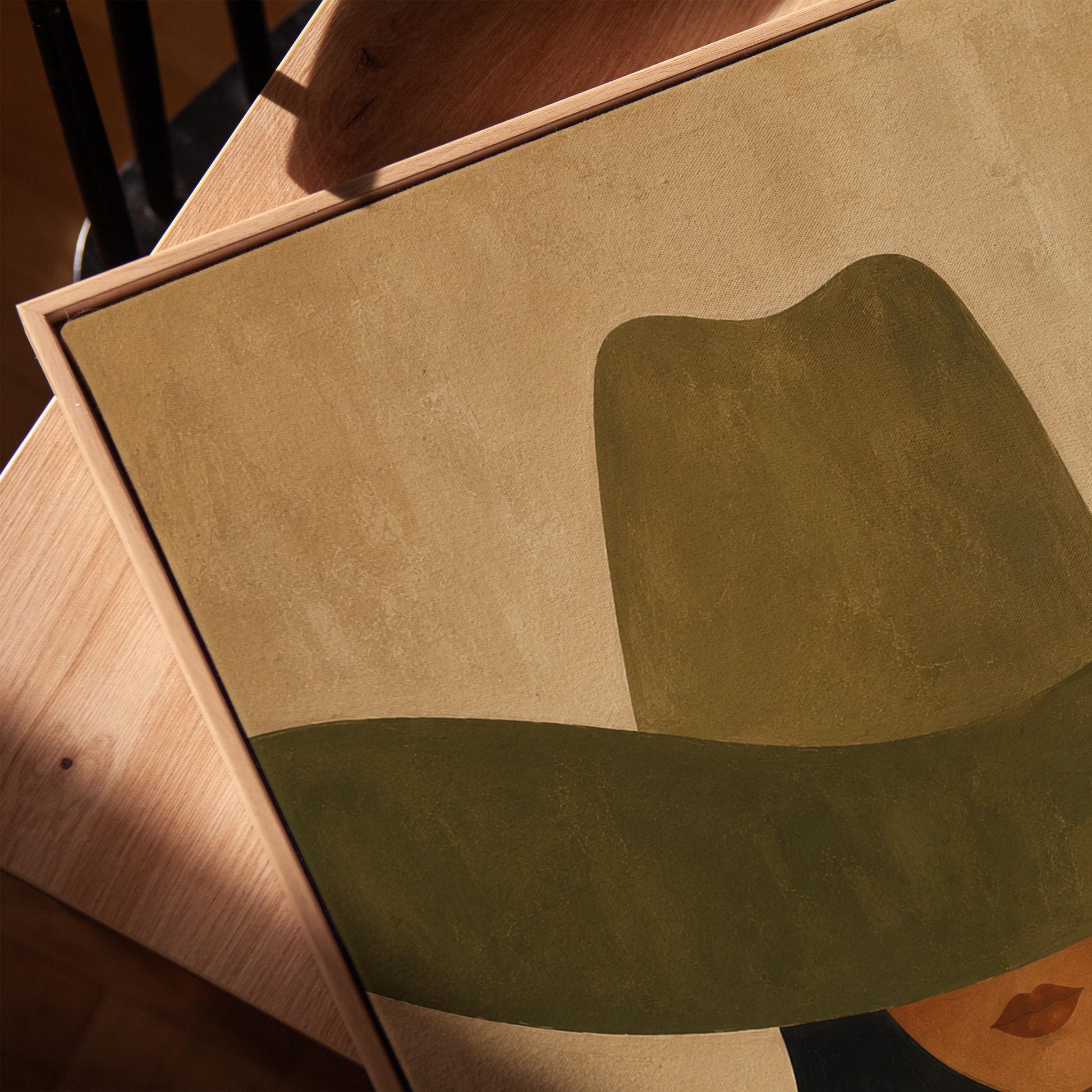 Cropped cowgirl face beneath the sweeping brim of a large olive hat, canvas print in a warm, minimally styled interior
