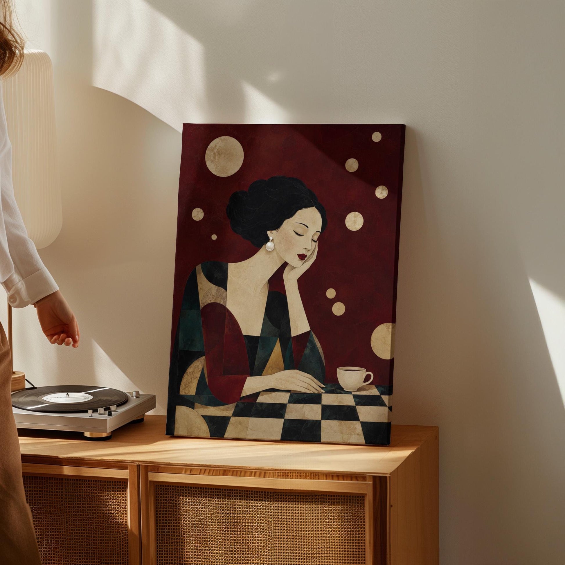 Art deco woman resting her chin on her hand beside a white coffee cup, canvas wall art presented in a light, minimal room