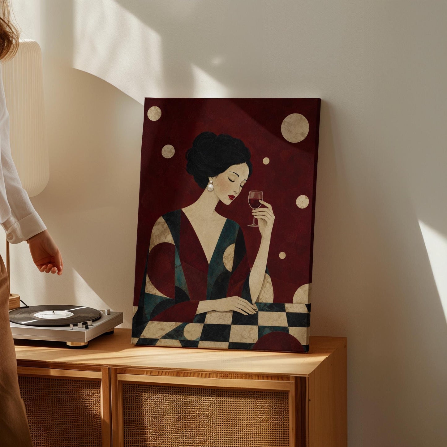 Woman with closed eyes lifting a glass of red wine at a dark table, canvas print styled against a soft white wall