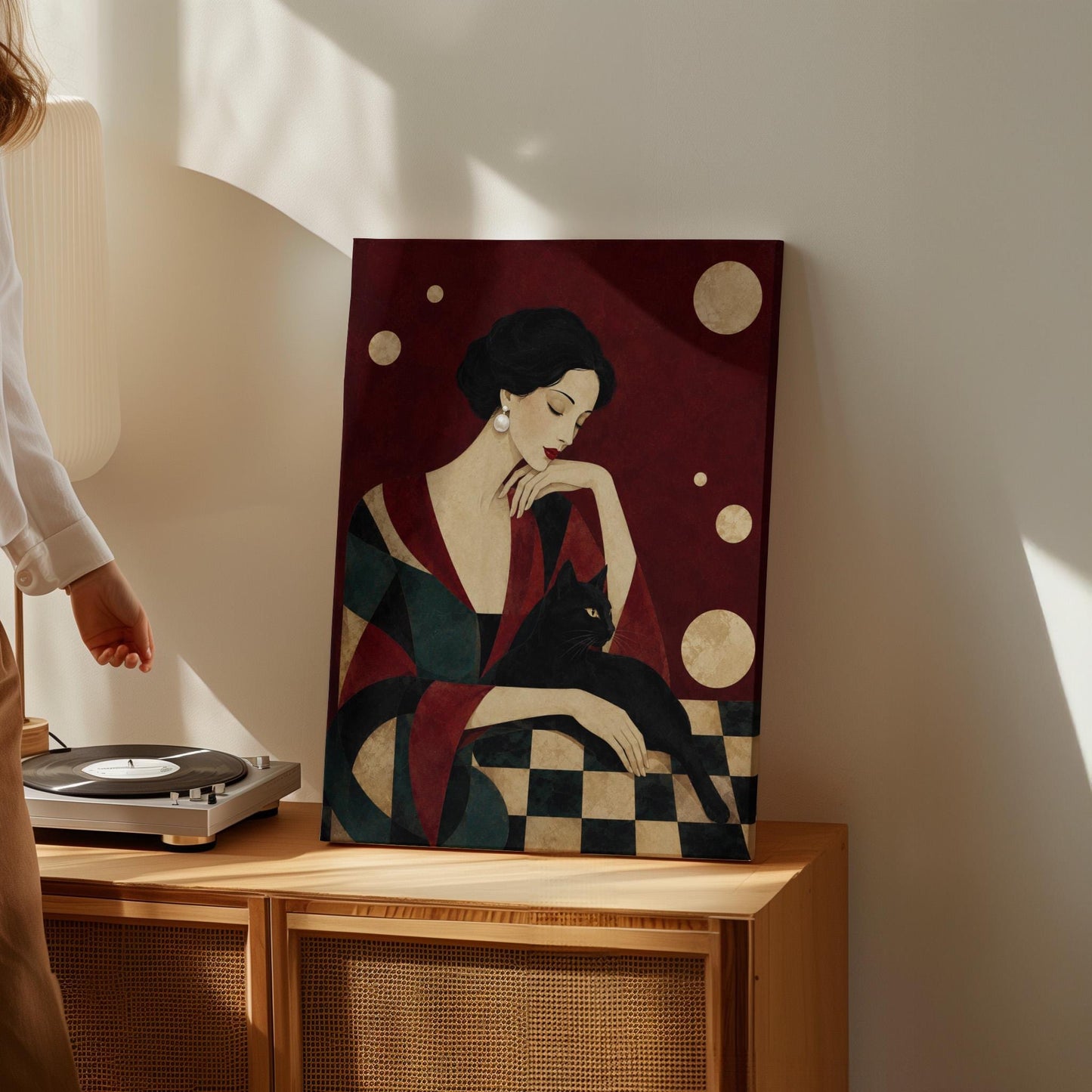 Elegant woman seated with a sleek black cat curled against her arm, canvas print hanging in a calm, modern living space
