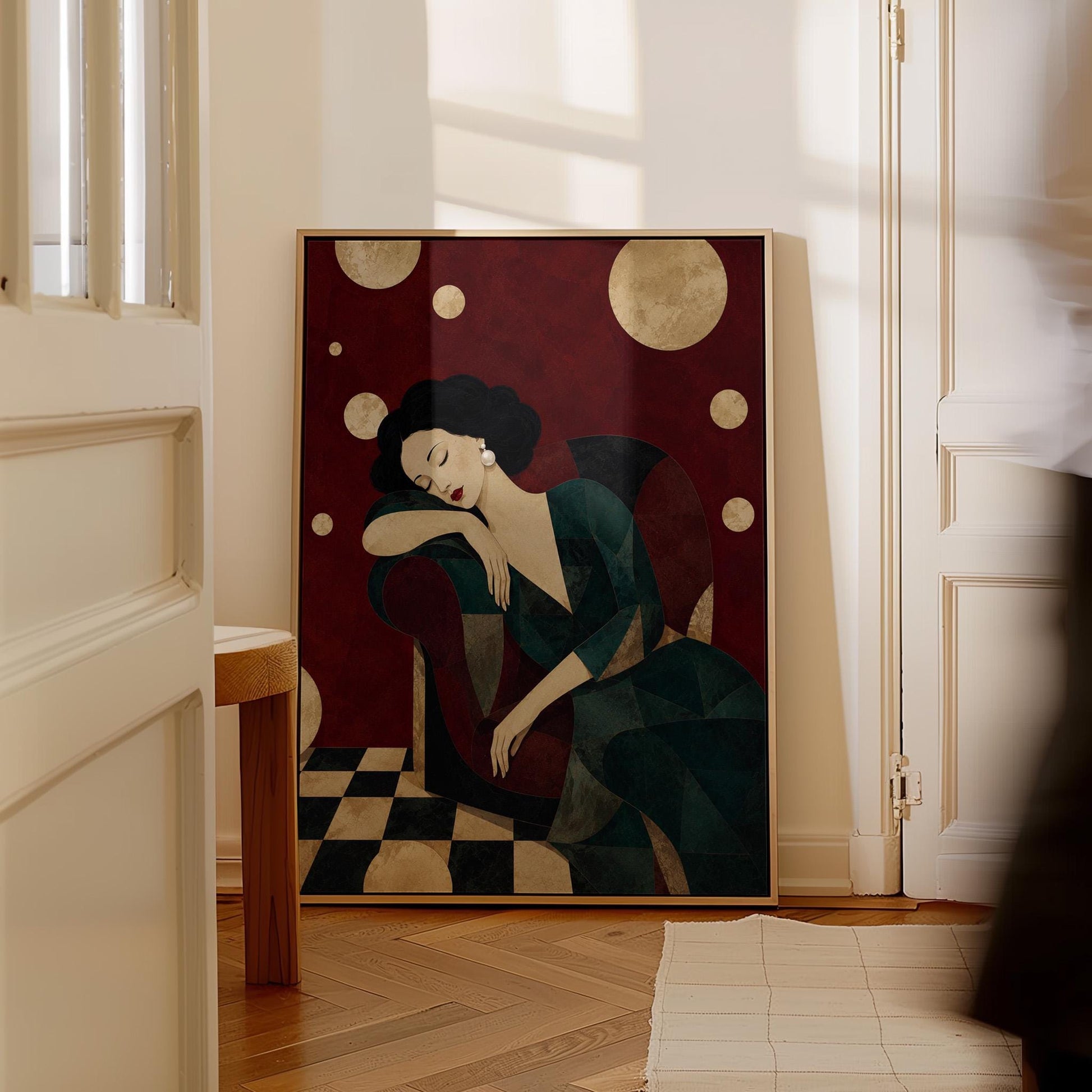 Dark haired woman asleep draped over the back of a deep red armchair, canvas print styled against a soft white wall