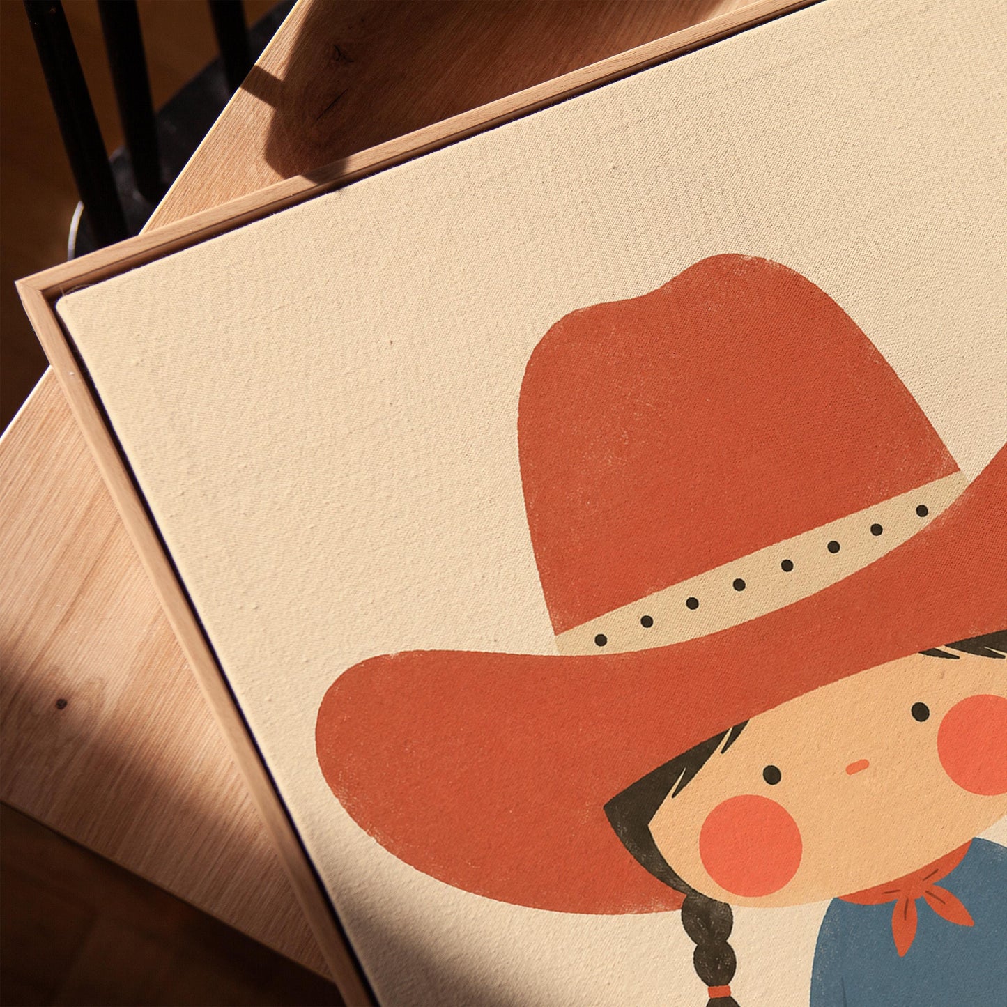 Little cowgirl with braids and rosy cheeks under an oversized red hat, canvas print in a warm, minimally styled interior