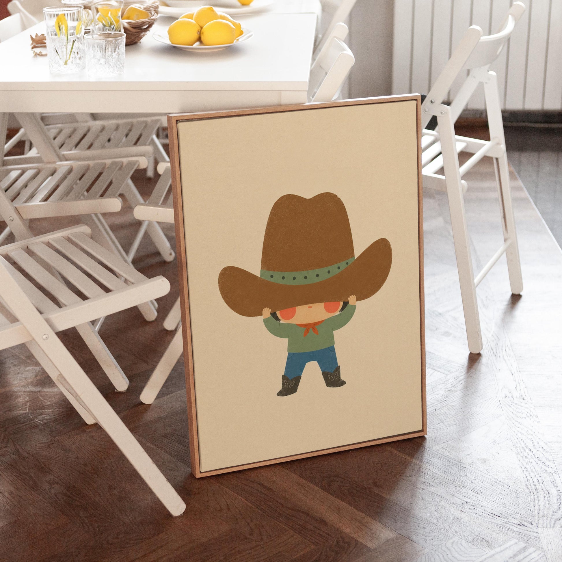Child lifting an enormous brown cowboy hat above their eyes, canvas wall art on a quiet wall in a considered interior