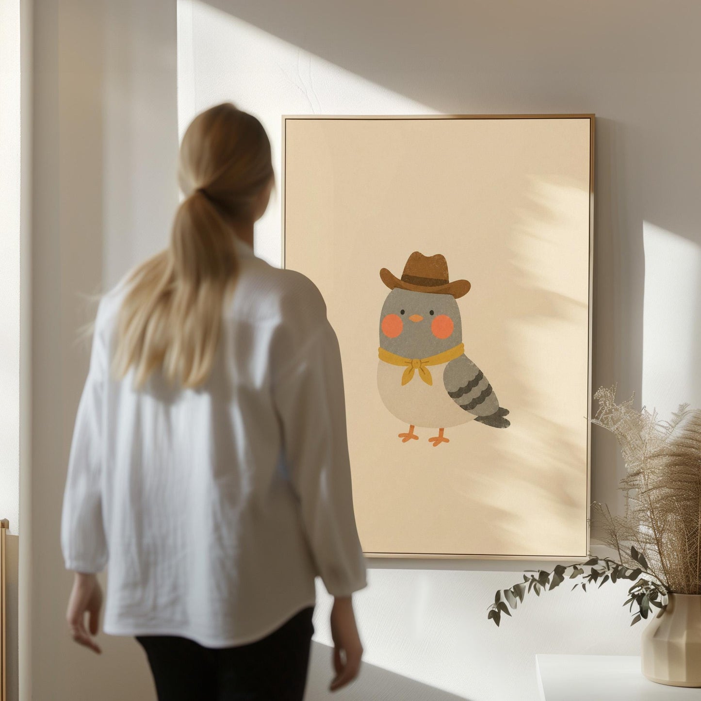 Round grey bird wearing a tiny cowboy hat and yellow bandana, canvas print hanging in a calm, modern living space