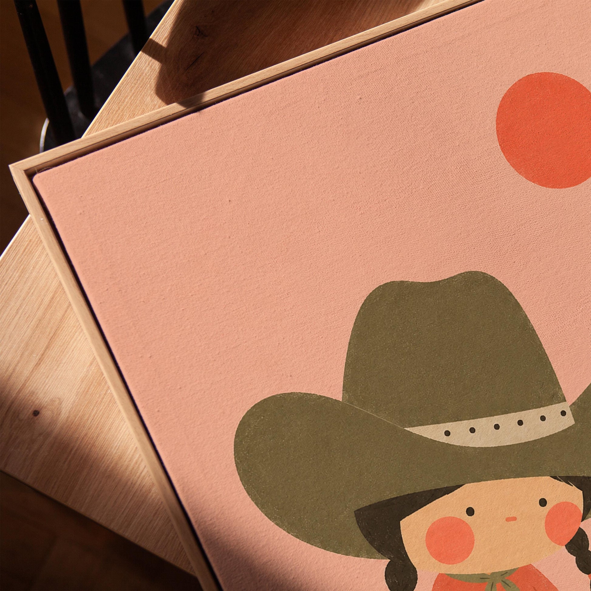 Cowgirl in a green hat watering a small flower in the desert, canvas print in a warm, minimally styled interior