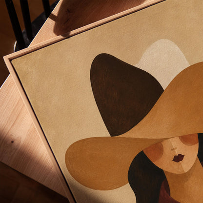 Cowgirl in a black and brown hat wearing a cow print shirt, canvas print in a warm, minimally styled interior