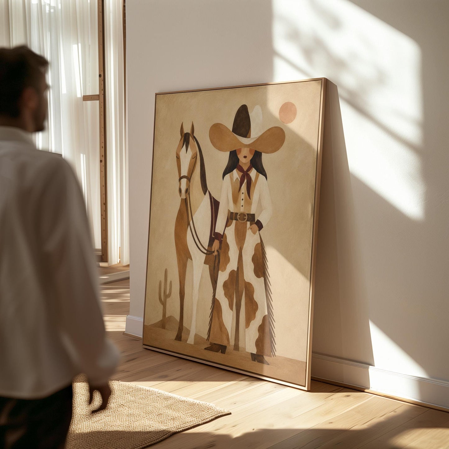 Cowgirl in cow print chaps standing beside a horse in a warm desert scene, canvas print shown in a sunlit, contemporary room