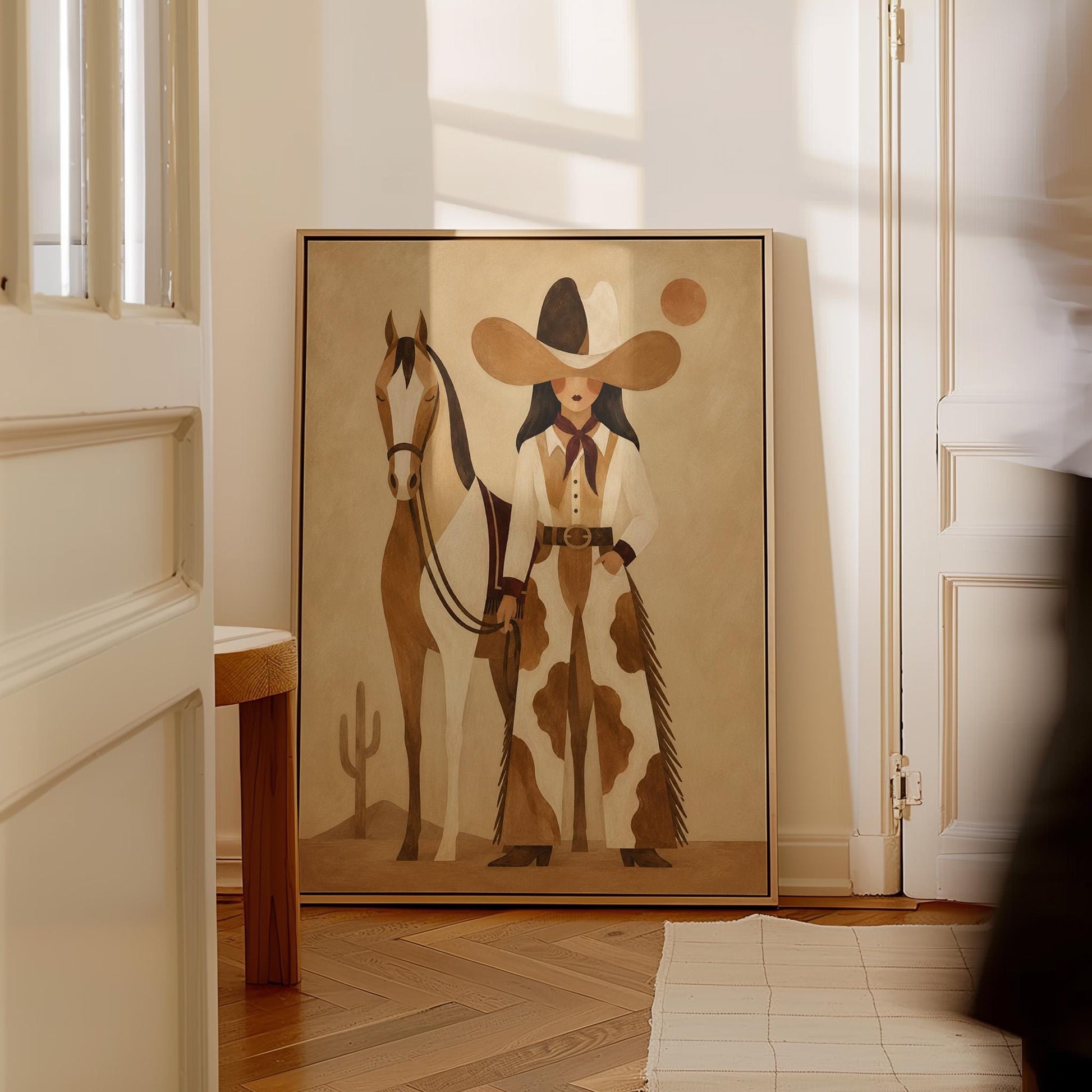 Cowgirl in cow print chaps standing beside a horse in a warm desert scene, canvas print on a quiet wall in a considered interior