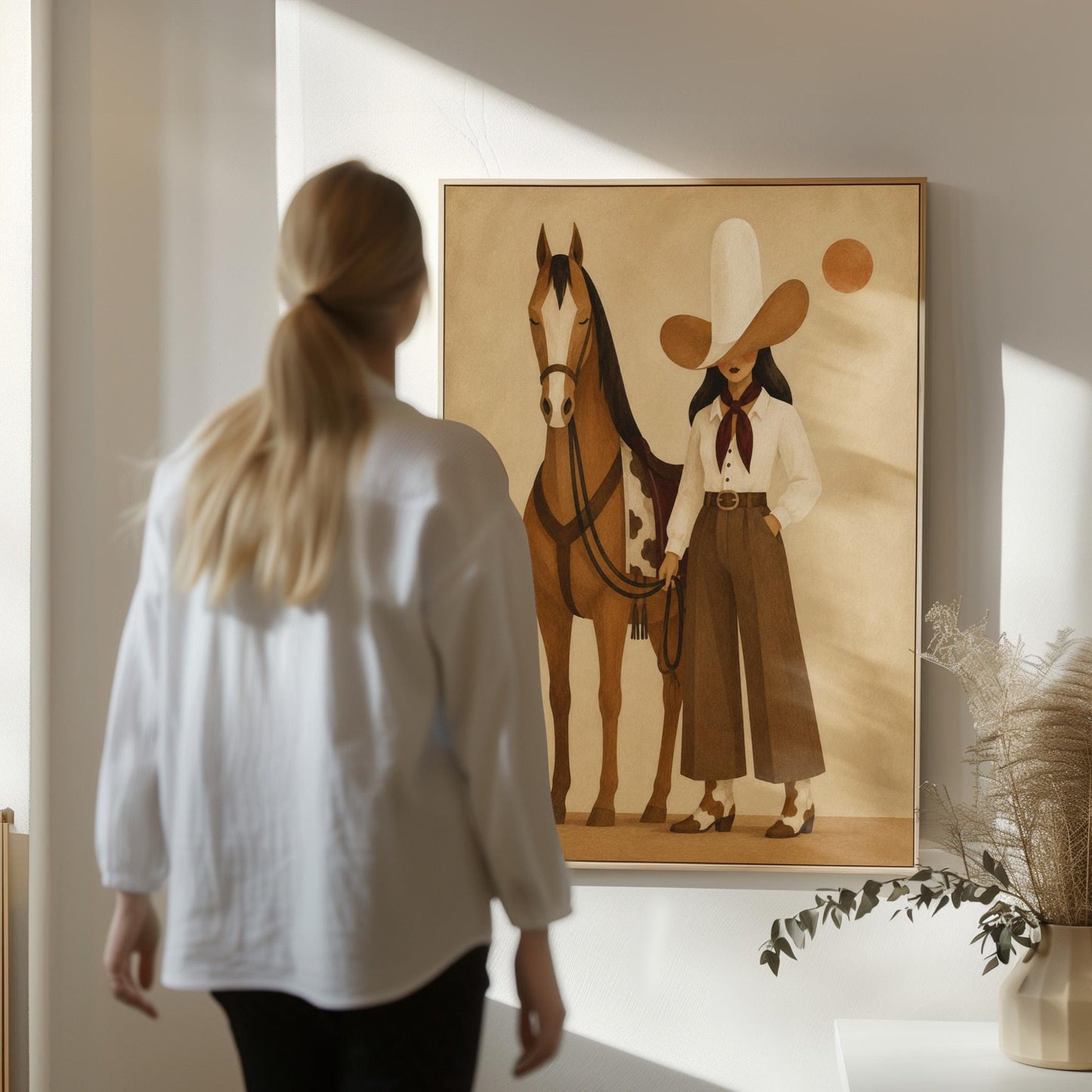 Cowgirl in a pale wide brim hat holding the reins of a bay horse at dusk, canvas print hanging in a calm, modern living space