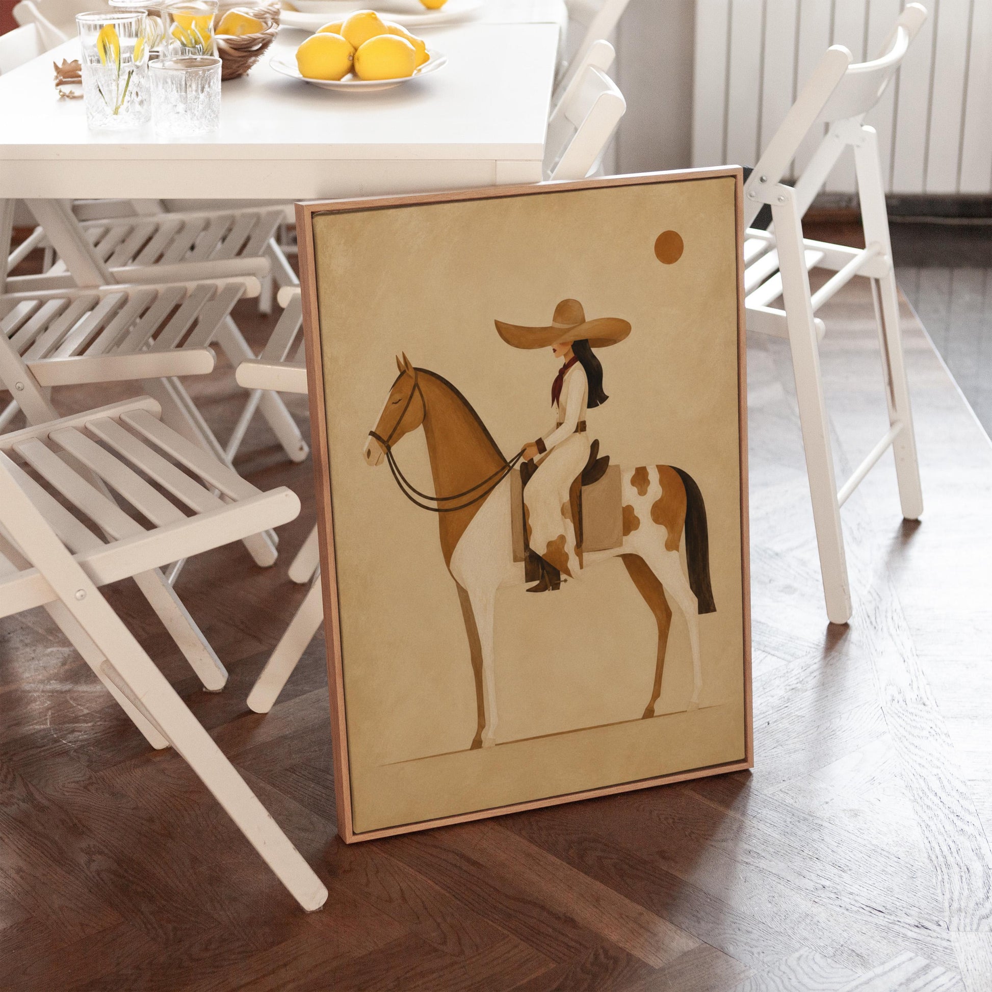 Cowgirl in a broad straw hat riding a cream and chestnut pinto horse, canvas print seen in a warm interior with natural light