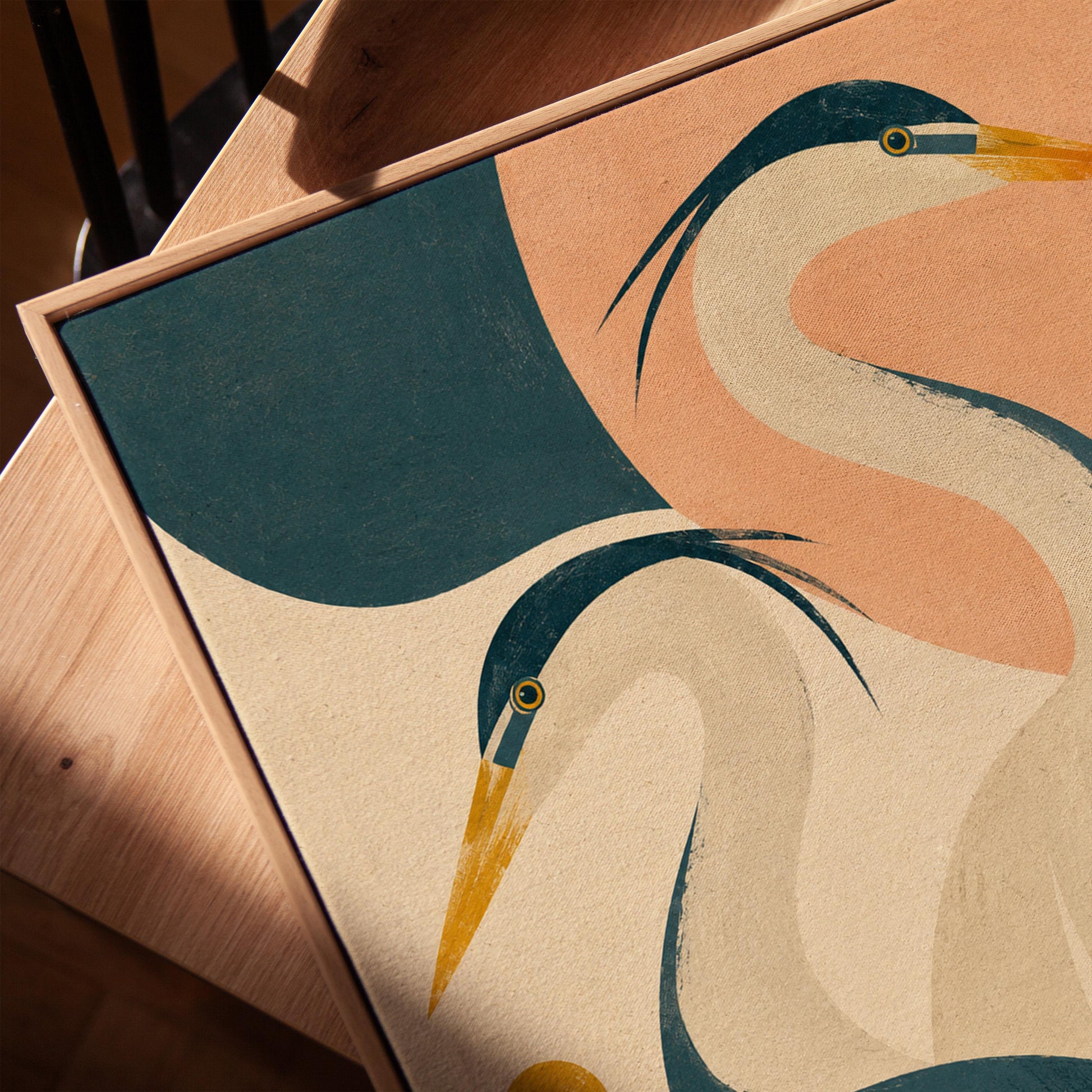 Two great herons with yellow beaks against a peach and teal sky, canvas print in a warm, minimally styled interior