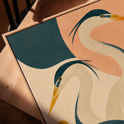 Two great herons with yellow beaks against a peach and teal sky, canvas print in a warm, minimally styled interior