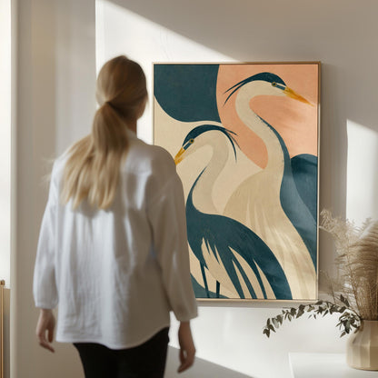 Two great herons with yellow beaks against a peach and teal sky, canvas print presented in a light, minimal room