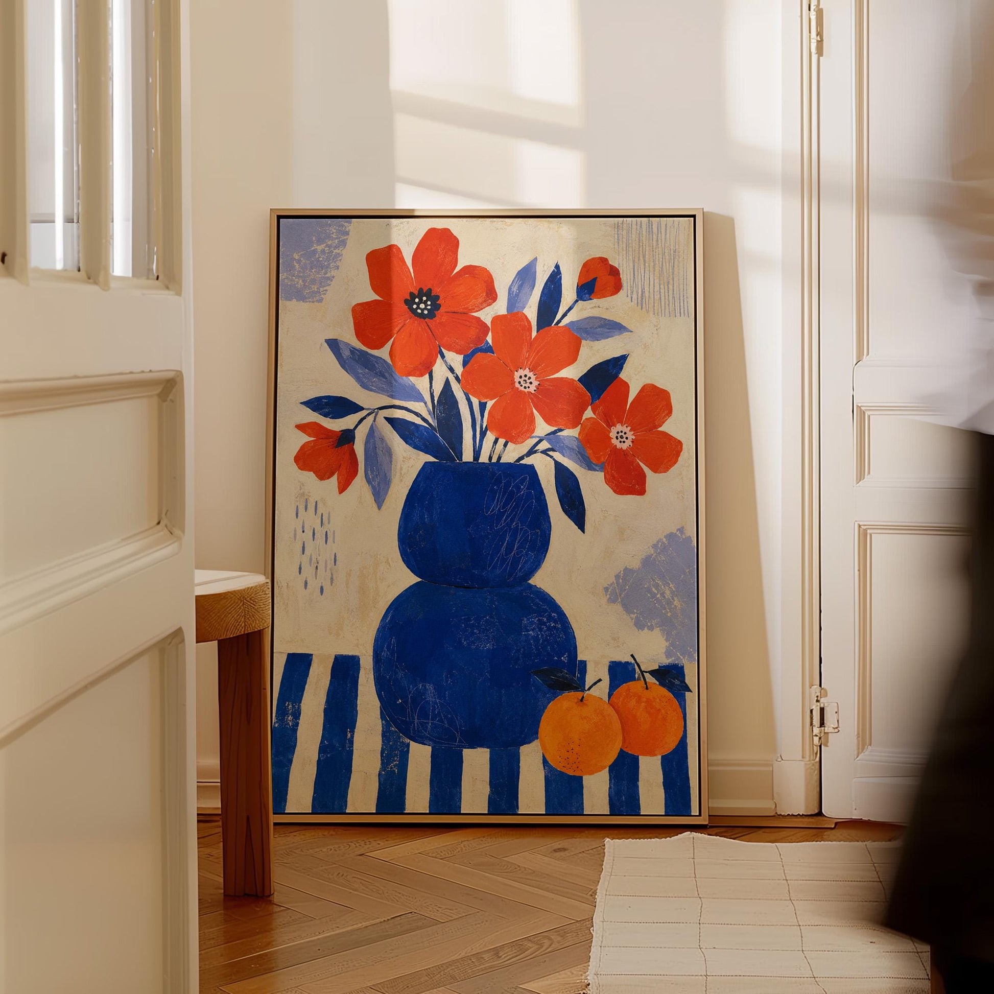 Scarlet poppies in a cobalt vase with oranges on a blue striped cloth, canvas print hanging in a calm, modern living space