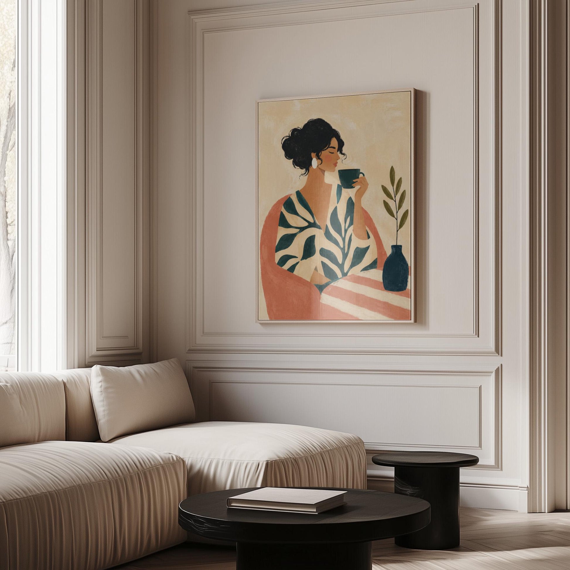 Woman in a leaf print robe drinking from a teal cup beside a vase, canvas print presented in a light, minimal room