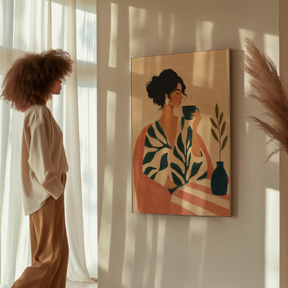 Woman in a leaf print robe drinking from a teal cup beside a vase, canvas print displayed on a neutral wall in a styled interior